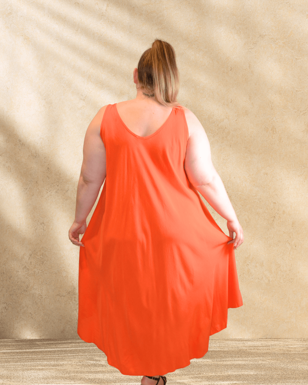 Mannequin de dos portant la robe Paule orange.