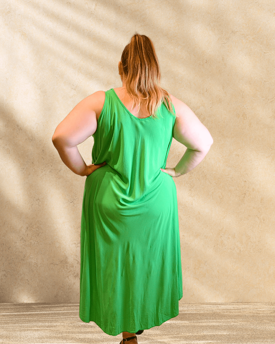 Mannequin de dos portant la robe Paule vert brésil.